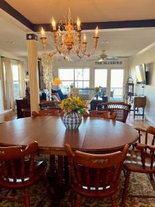 a dining room with a table and a chandelier at The Lookout House at The Bluebird in Eureka Springs