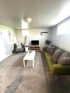 a living room with a green couch and a table at Cozy basement apartment - blocks from Old Town in Pocatello