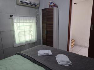 a bedroom with a bed with two towels on it at Seu lar in São José +3 photos