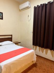 - une chambre avec un lit et un rideau noir dans l'établissement Xpress Inn, à Veracruz