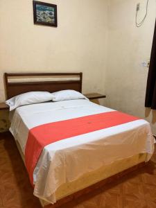 a bed with a red and white blanket on it at Xpress Inn in Veracruz +8 photos