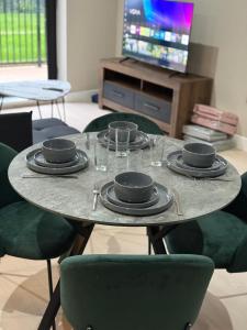 a table with plates and glasses on top of it at Quality City Green Luxury Apts Close to NEC & Airport in Birmingham