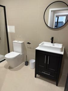a bathroom with a toilet and a sink and a mirror at Quality City Green Luxury Apts Close to NEC & Airport in Birmingham