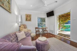 a living room with a purple couch and a table at Little Chelsea in Moss Vale