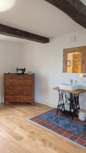 a bathroom with a sink and a wooden dresser at Dépendance du château de Remehan rénovée avec goût in Pouru-Saint-Rémy