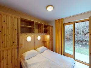 a bedroom with a bed and a large window at Comfy apartment with terrace in Nendaz +19 photos