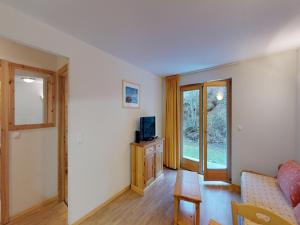 a living room with a couch and a television at Comfy apartment with terrace in Nendaz