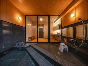 ein Badezimmer mit Dusche und Toilette in der Unterkunft BEPPU Sento in Beppu + 26 Fotos