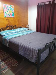 a bed in a room with a red curtain at Cabaña Mariza in Trapiche