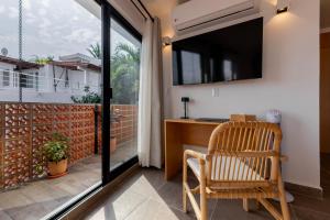 a home office with a desk and a large window at Raices Nomadas Boutique Hotel Vallarta in Puerto Vallarta