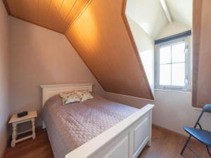 a small bedroom with a bed and a window at 6-person house with a beautiful garden in Wemeldinge