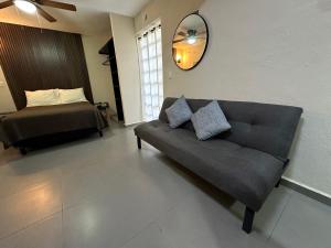 una sala de estar con un sofá y una cama en Peach35L Céntrico studio super ubicado y tranquilo, en Cancún