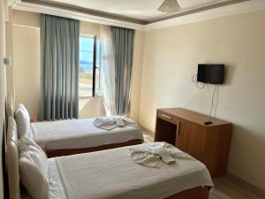 a hotel room with two beds and a window at Grand Alver Otel in Edremit