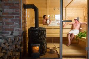 a man and a woman sitting in a sauna at Pałac Galiny in Bartoszyce- Galiny