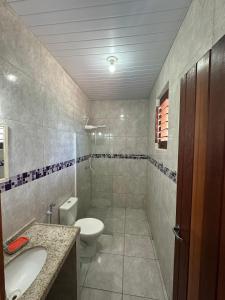 a bathroom with a toilet and a sink at Chalé Aroeira Taiba in Taíba