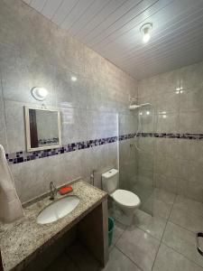a bathroom with a sink and a toilet and a shower at Chalé Aroeira Taiba in Taíba