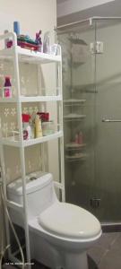 a bathroom with a toilet and a glass shower at Capsule bed room in Manila