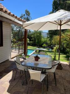 a table and chairs with an umbrella on a patio at Casa lago rapel in Lago Rapel