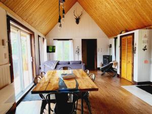a living room with a wooden table and a couch at Chalet L'Apéro des Chutes - Spa, détente & nature au bord de l'eau en Mauricie in  Notre-Dame de Montauban
