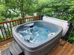 a hot tub sitting on a wooden deck at Chalet L'Apéro des Chutes - Spa, détente & nature au bord de l'eau en Mauricie in  Notre-Dame de Montauban