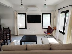a living room with a couch and a flat screen tv at Casa del Algarrobo in Cafayate