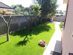 a yard with a fence and a bowl of flowers at Il Bacio di Roma in Infernetto