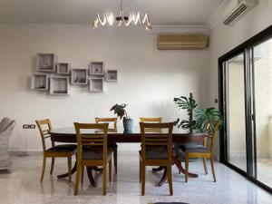 a dining room with a table and chairs at antelias mainroad apartment in An Naqqāsh +22 photos