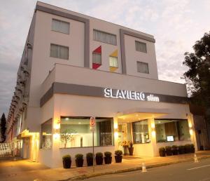 a large white building with a sign on it at Slim Joinville by Slaviero Hotéis in Joinville