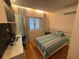 a small bedroom with a bed and a window at Suíte Home Office no Cruzeiro in Brasília