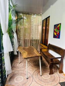 a wooden bench sitting in a room with a window at Casa Teo número 2 in Puerto Viejo