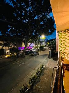 a city street at night with cars on the road at Casa Almanik Hostel in Medellín +29 photos