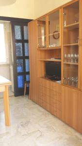 kuchnia z dużą drewnianą szafką ze szklanymi drzwiami w obiekcie Valter Apartment w mieście Pietra Ligure