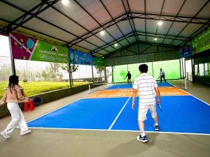 a group of people playing tennis on a tennis court at Đồi Mây Homestay Bảo Lộc in Bảo Lộc +46 photos