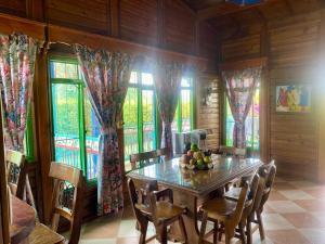 a dining room with a table and chairs and windows at Horizonte del Quindío - Chalet privado in Quimbaya