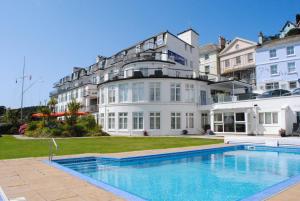 a hotel with a swimming pool in front of a building at 37 The Salcombe in Salcombe