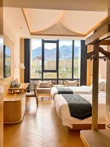 a bedroom with two beds and a large window at Tai'an Jianguo Puyin Garden Hotel in Tai'an