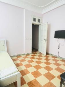 Nhà nghỉ Vườn Đào في هانوي: غرفة ذات أرضية مربعة وأريكة بيضاء