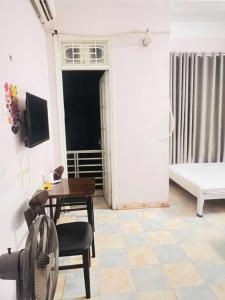 Nhà nghỉ Vườn Đào في هانوي: غرفة معيشة بها طاولة وكراسي وسرير