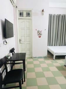 Nhà nghỉ Vườn Đào في هانوي: غرفة معيشة مع طاولة وباب