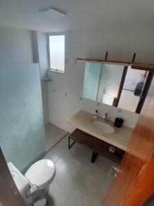 a bathroom with a sink and a toilet and a mirror at Apartamento Cobertura vista ao mar churrasqueira Prainha Arraial do Cabo in Arraial do Cabo