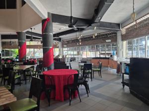 Un restaurante con mesas y sillas con mantel rojo. en 13pax GLORY EXECUTIVE SUITE 3R3B, DOORSTEP BEACH, POOL, BBQ, Wifi, 50"TV, en Port Dickson