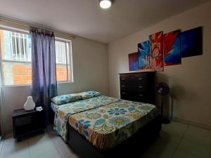um quarto com uma cama, uma cômoda e uma janela em Casa Familiar 4 Habitaciones con Agua Caliente, WiFi y Patio - Acepta Mascotas em Pereira