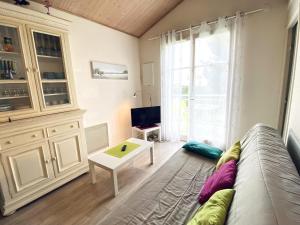 a living room with a couch and a table at T2 Mezzanine aux Sables d'Olonne - Balcon, Proche Plage et Commerces - FR-1-92-745 in La Pironnière