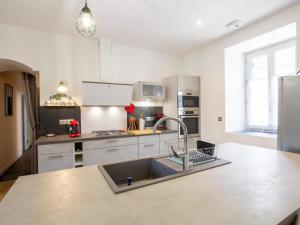 a kitchen with white cabinets and a sink at Maison de Charme avec Jardin, Activités de Plein Air et Proche Sites Touristiques - FR-1-616-333 in Tourtoirac