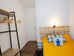 a bedroom with a yellow bed with blue pillows at Maison de Charme avec Jardin, Activités de Plein Air et Proche Sites Touristiques - FR-1-616-333 in Tourtoirac