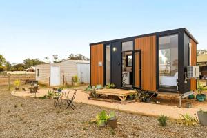 a black and orange tiny house with a backyard at Inspired Tiny Home by Tiny Away in Cabarita