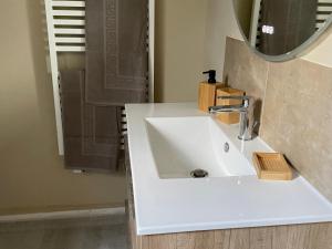 une salle de bains avec un lavabo blanc et un miroir dans l'établissement Gîte calme près de La Flèche, idéal pour familles - FR-1-410-479, à Mansigné 28 autres photos