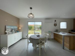 Charmant gîte avec terrasse à La Barre-de-Monts - FR-1-426-586 في لا باريه دي مونت: مطبخ وغرفة طعام مع طاولة وكراسي