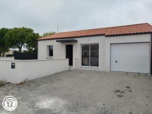 Charmant gîte avec terrasse à La Barre-de-Monts - FR-1-426-586 في لا باريه دي مونت: منزل أبيض عليه بابين لوقوف السيارات