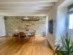a dining room with a stone wall and a table and chairs at Chaleureuse Maison à Groix, 5 pers, 3 chambres - FR-1-813-31 in Groix